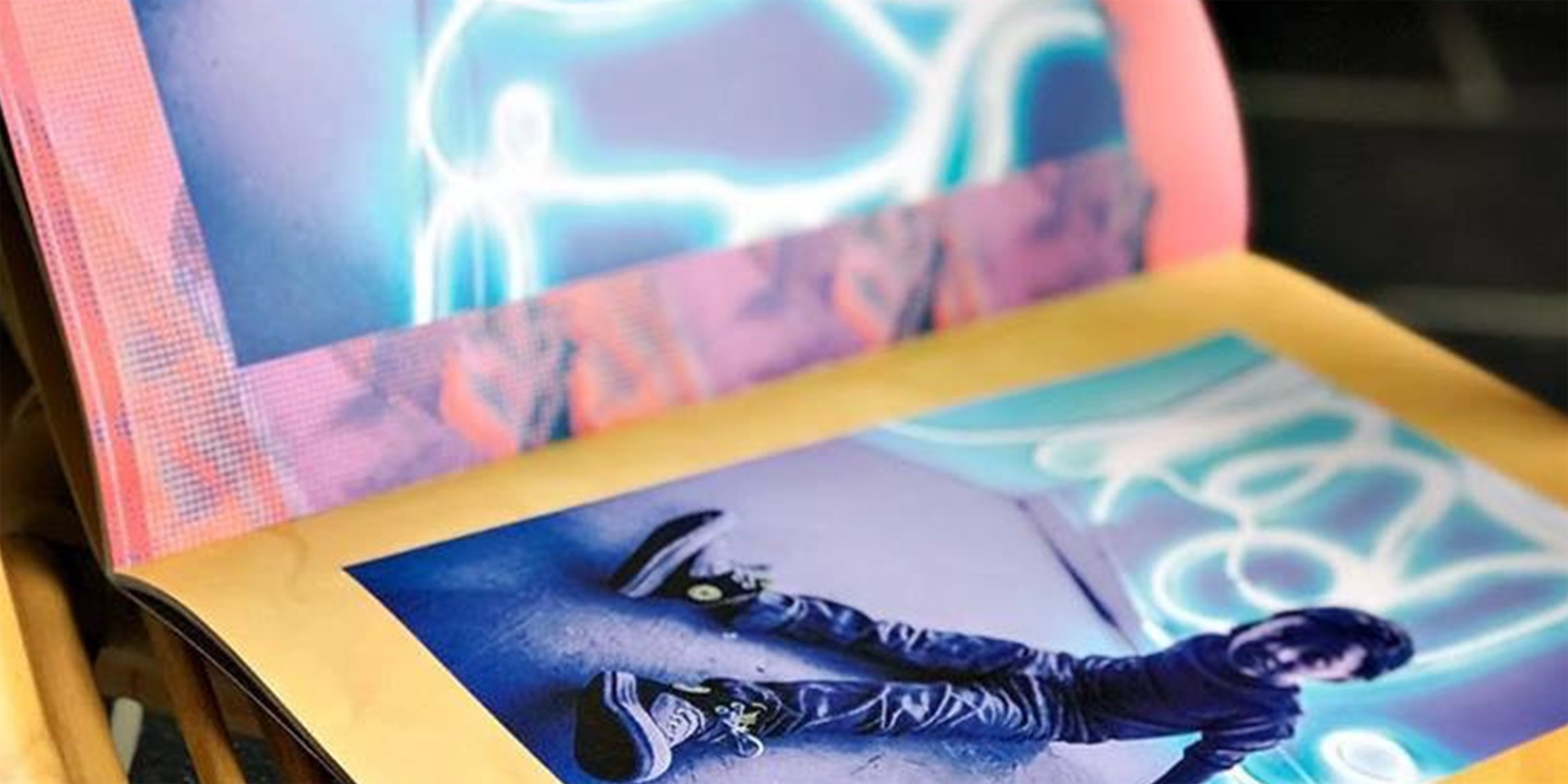 A photo of a colorful zine open and showing a photo of a child.